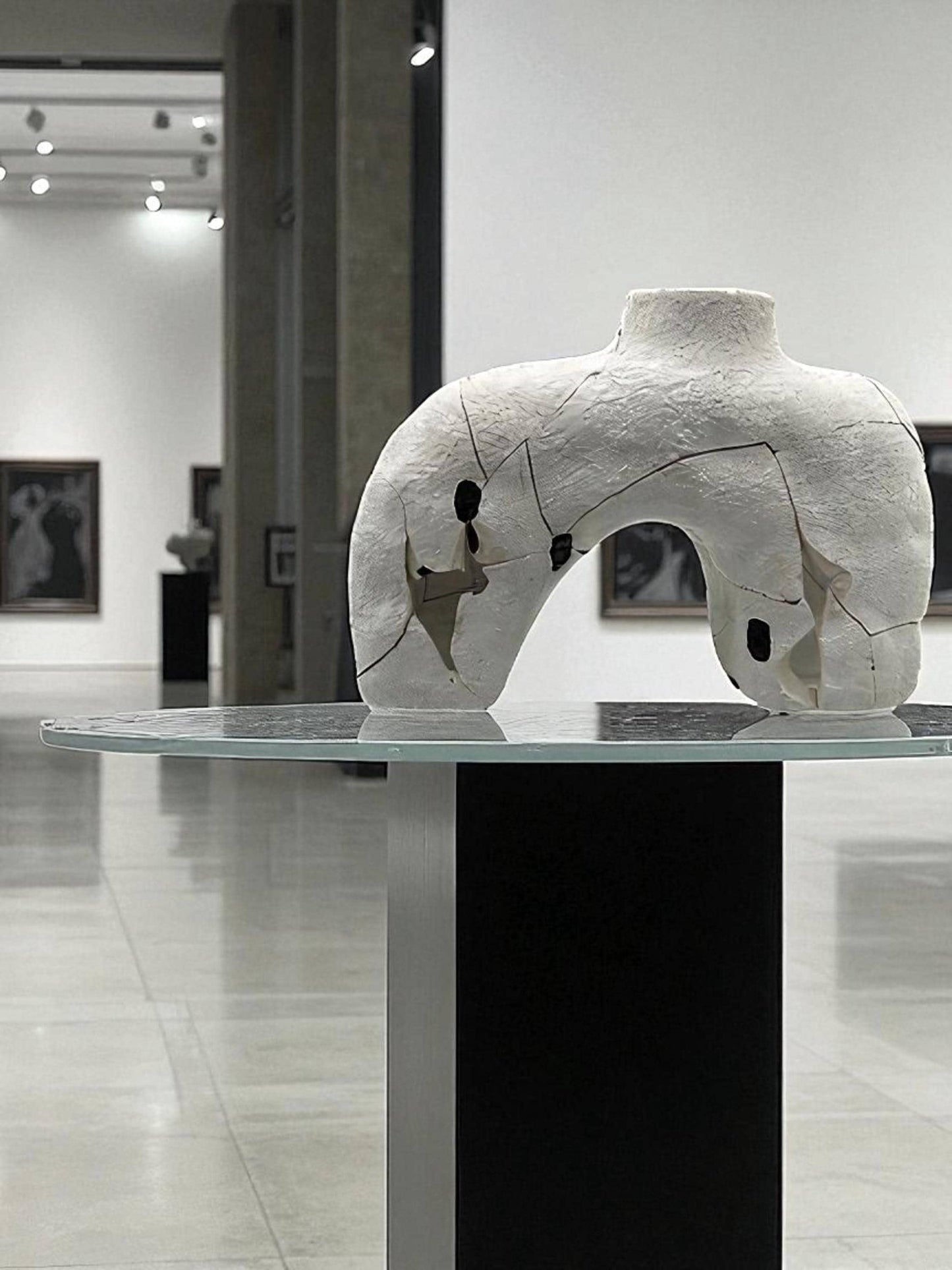 White cracked and repaired Japanese style Hachi vase on glass top pedestal in modern gallery setting