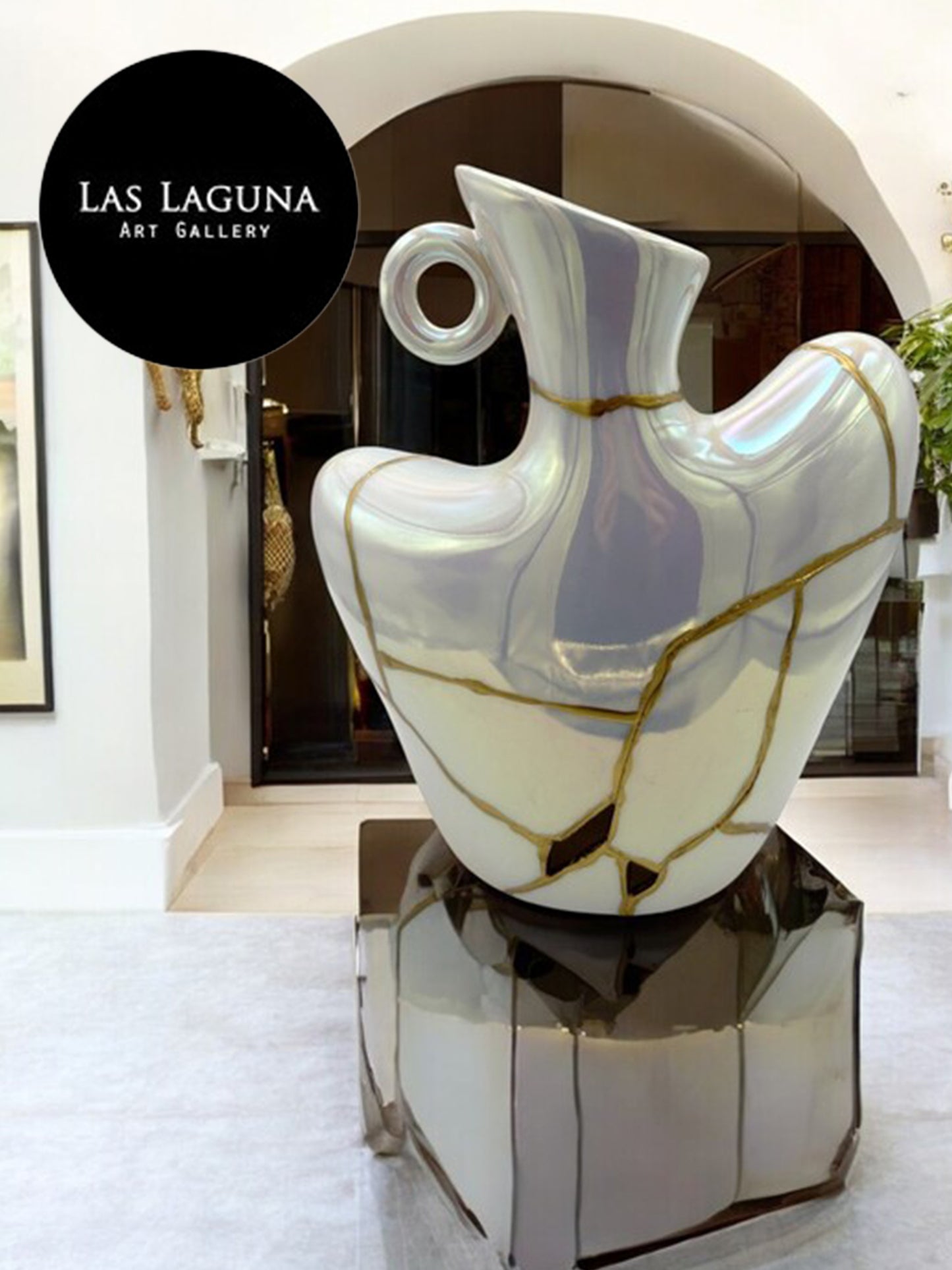 Iridescent ceramic bust vase with gold crackle design displayed on reflective pedestal at Las Laguna Art Gallery