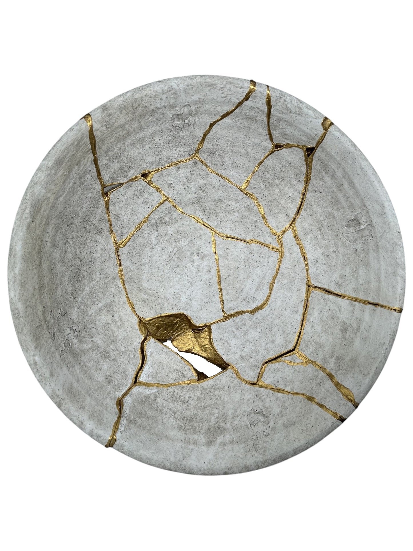 Round ceramic bowl repaired with gold kintsugi lacquer, showcasing natural cracks and minimalist gray texture on white background.