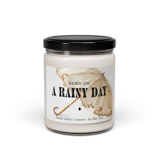 9oz glass jar candle labeled "Burn On A Rainy Day" with beige umbrella design and black lid on white background