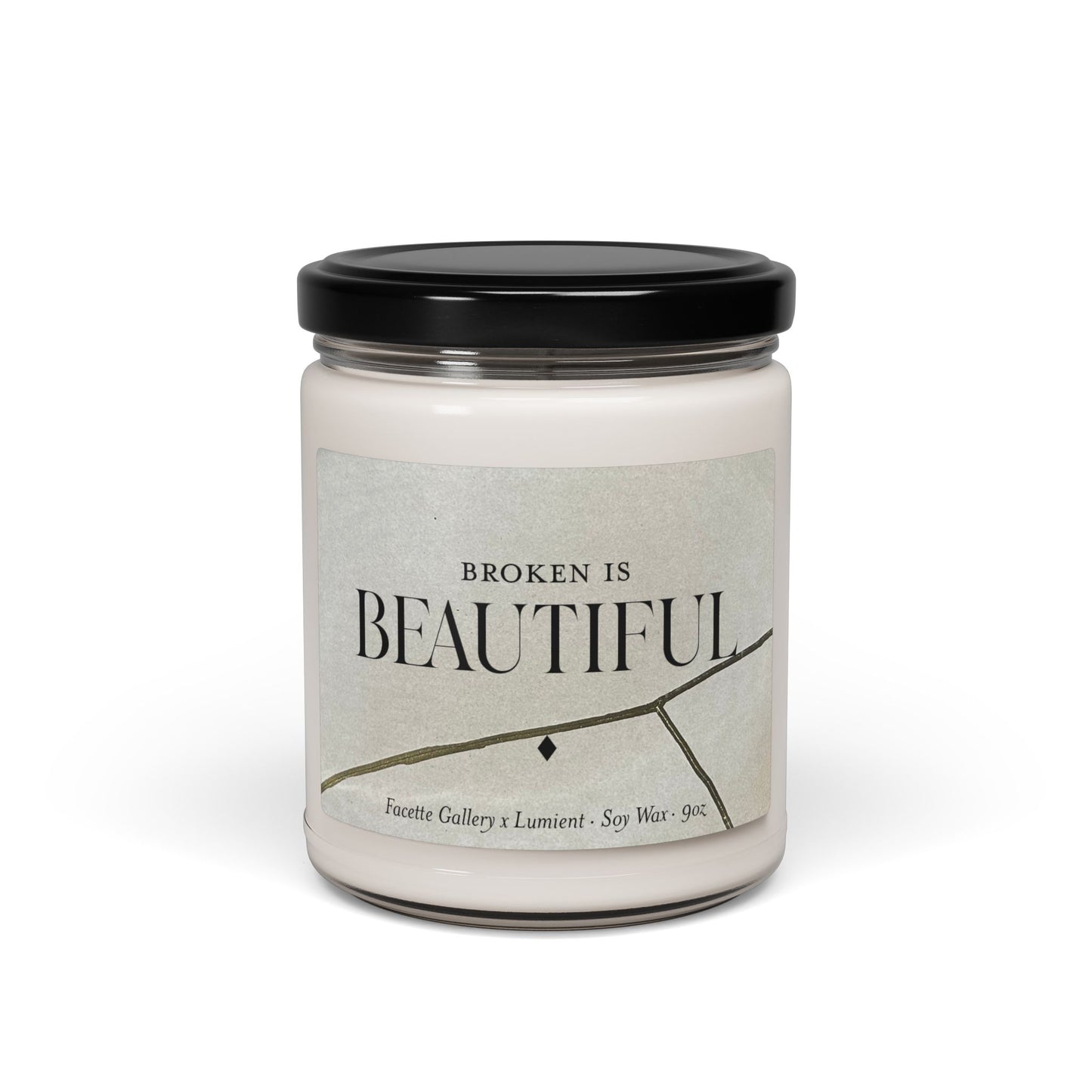 9oz beige soy candle in clear jar with black lid and "Broken is Beautiful" label featuring gold Kintsugi design