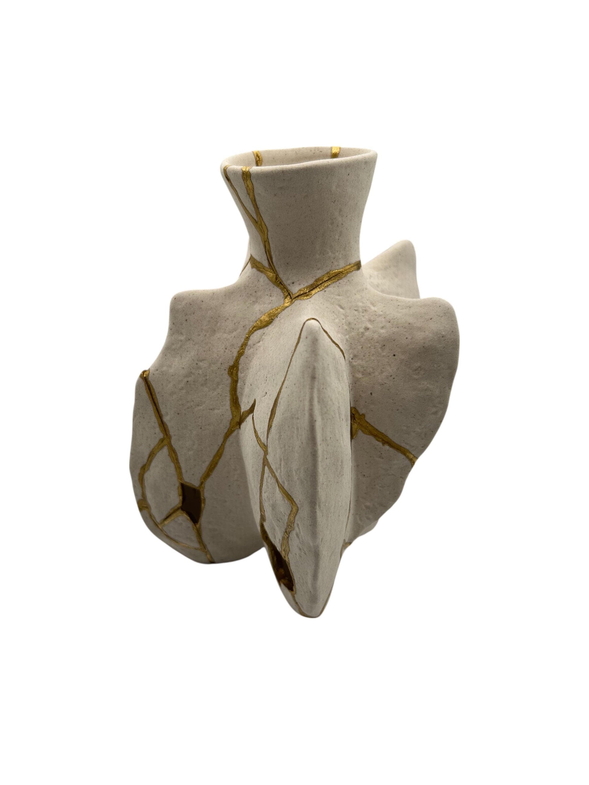 Handcrafted modern Kintsugi fossil vase with irregular shape and gold-painted repaired cracks on ivory pottery background