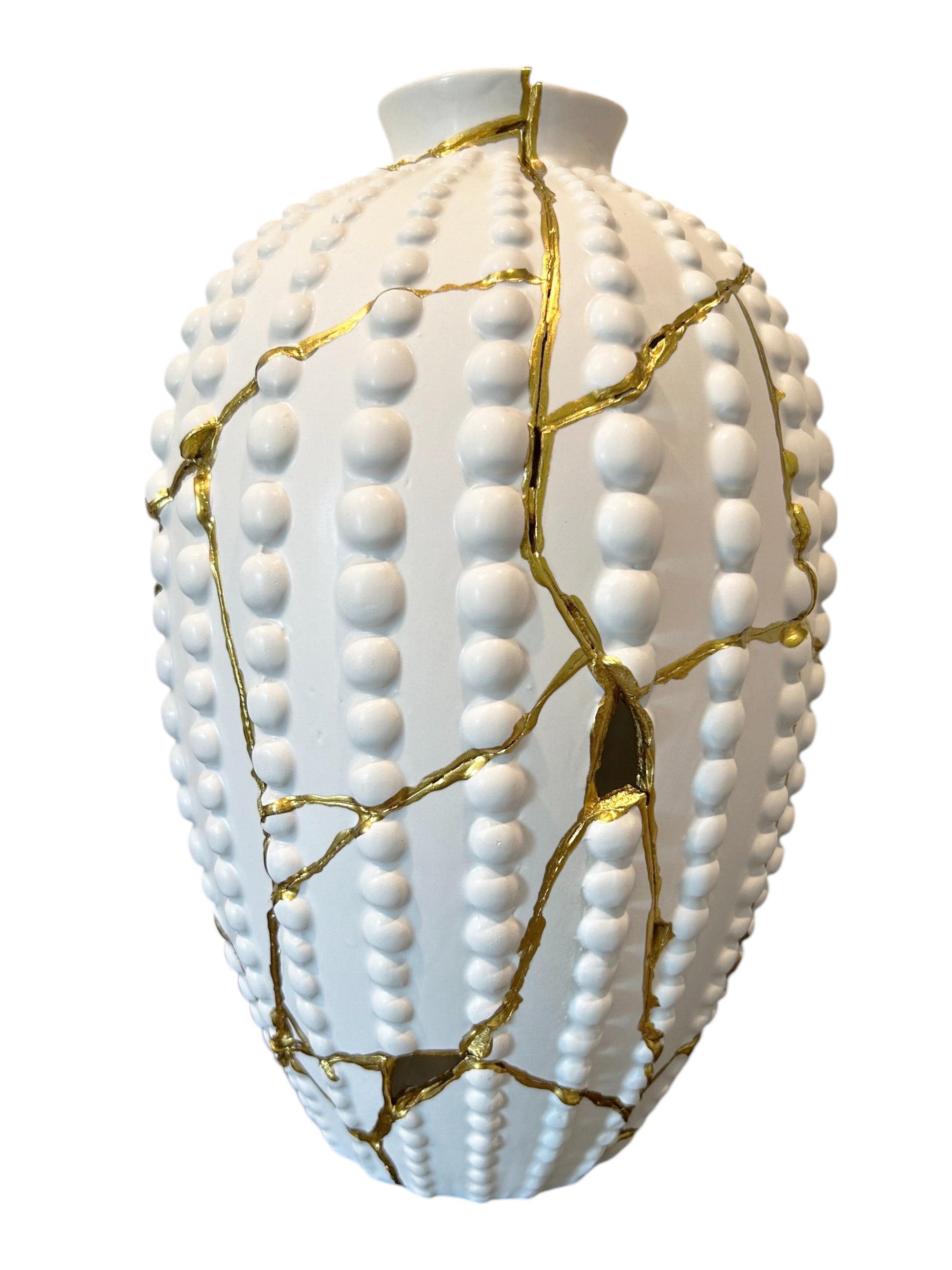 Modern Kintsugi sea urchin vase with white textured surface and gold hand-painted repaired cracks on white background