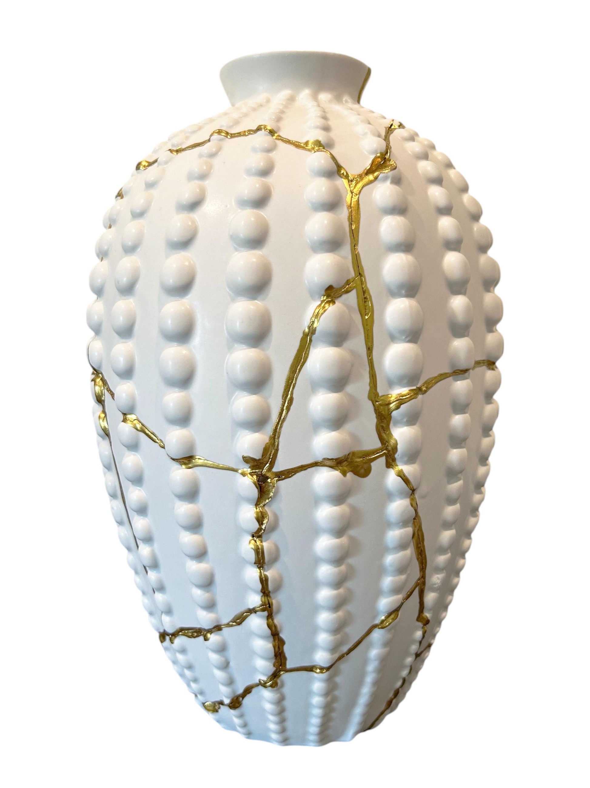 White ceramic sea urchin vase with raised dots and gold kintsugi-style repair lines, 12.5 inches tall.