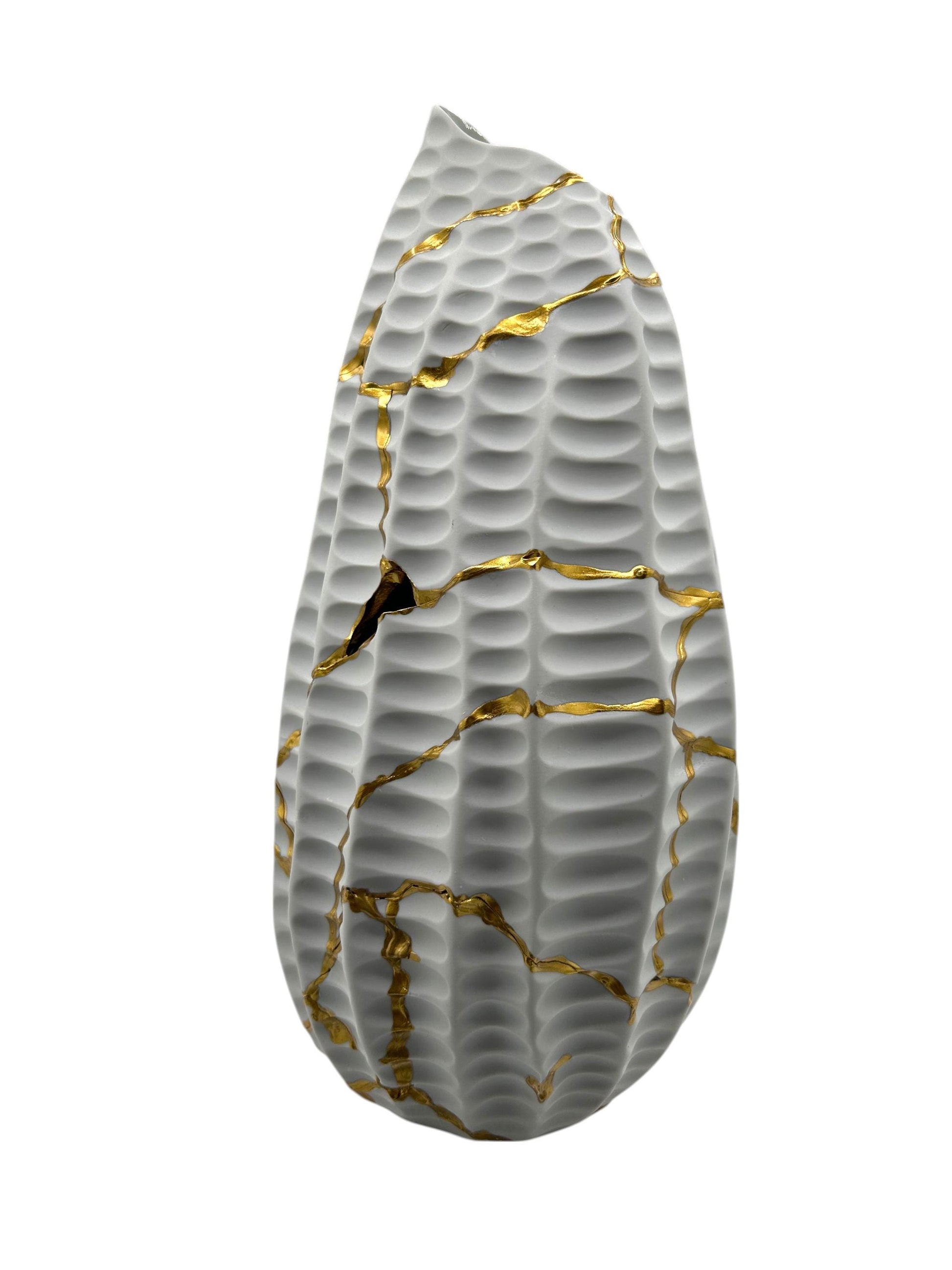 Modern Kintsugi seahorse-shaped ceramic vase with textured gray surface and hand-painted gold repair lines on white background