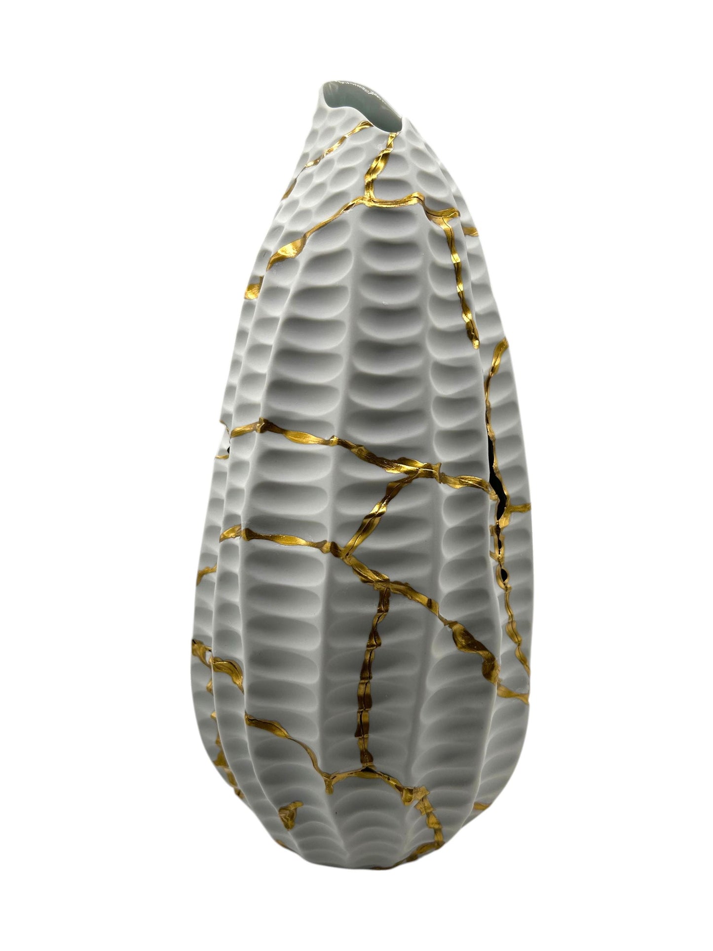 White ceramic vase with textured surface featuring gold kintsugi repairs in a modern sculptural design