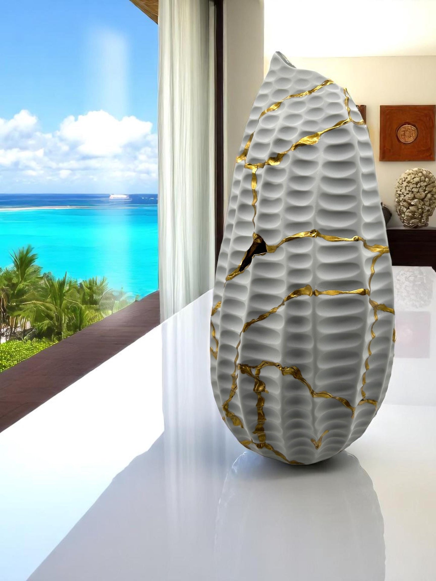 Modern white kintsugi seahorse vase with hand-painted gold cracks on glossy surface, displayed near ocean view window