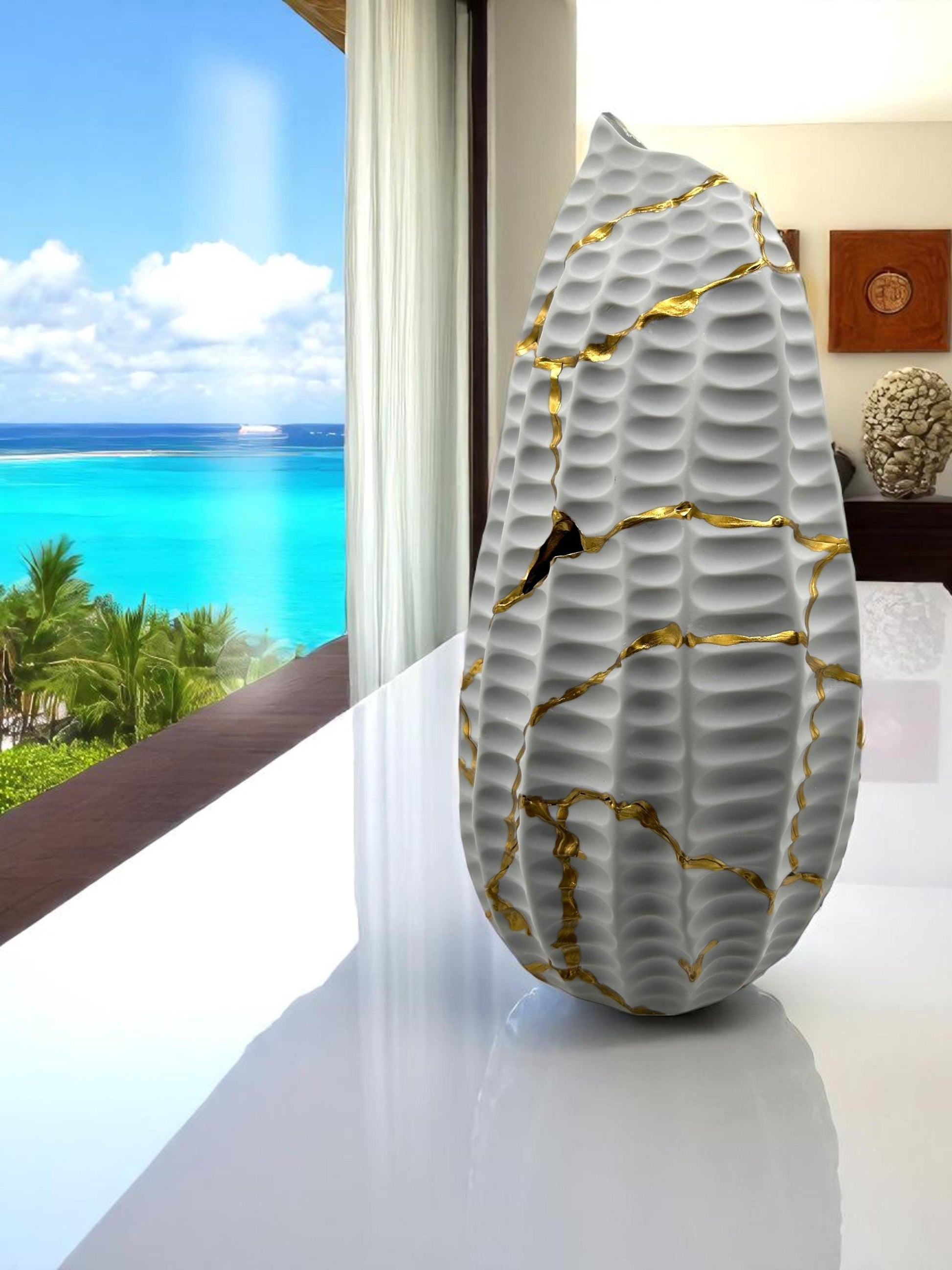 Modern white kintsugi seahorse vase with hand-painted gold cracks on glossy surface, displayed near ocean view window