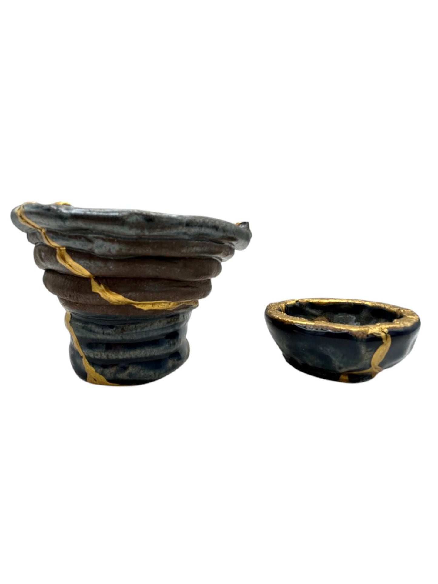 Two-piece set of modern Kintsugi ceramic bowls with hand-painted gold repair lines on dark blue pottery.