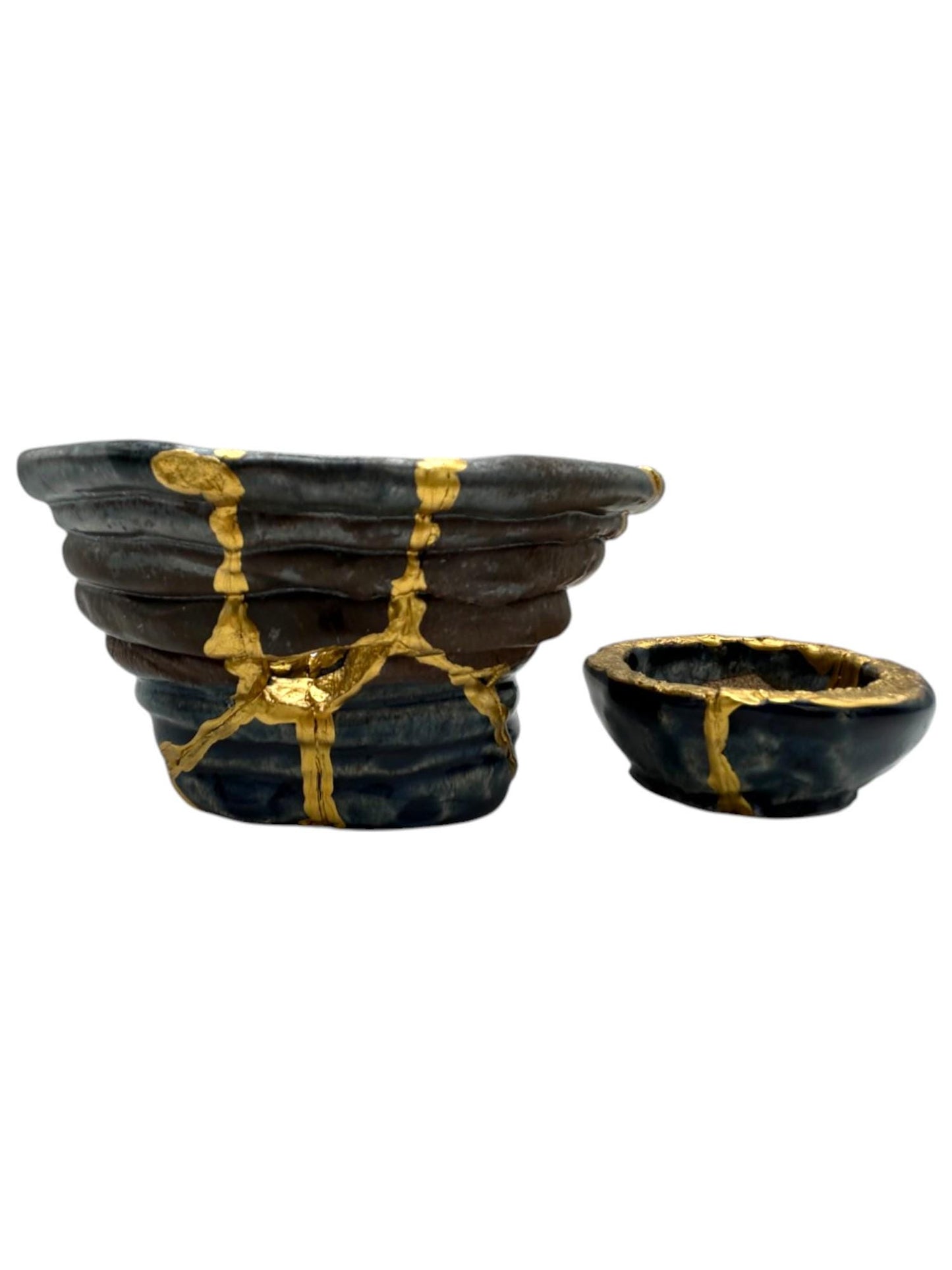 Set of two dark ceramic kintsugi bowls with hand-painted gold repairs, showcasing Japanese pottery art style.