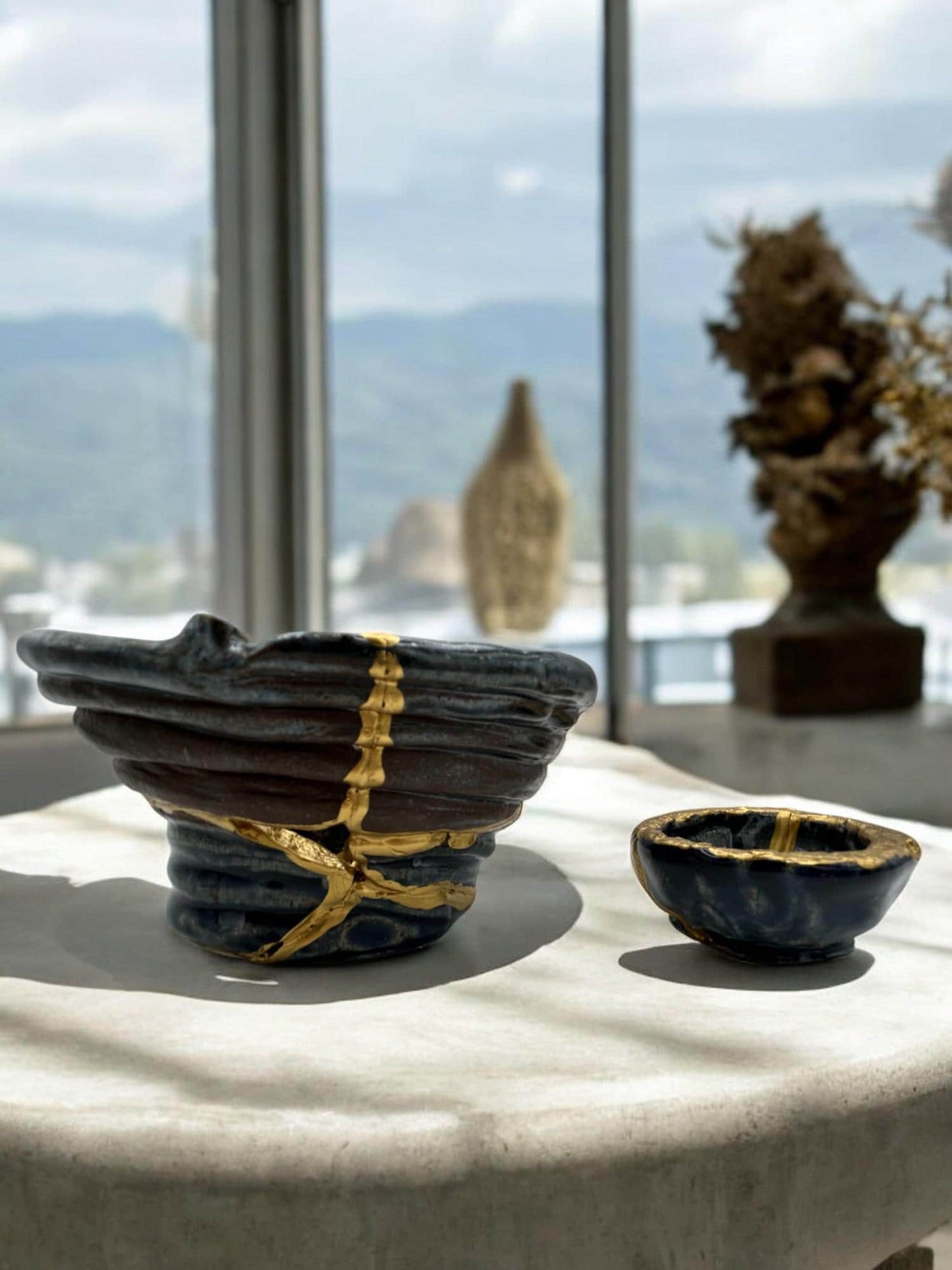 Two-piece modern kintsugi ceramic bowl set with hand-painted gold repairs displayed on a white surface