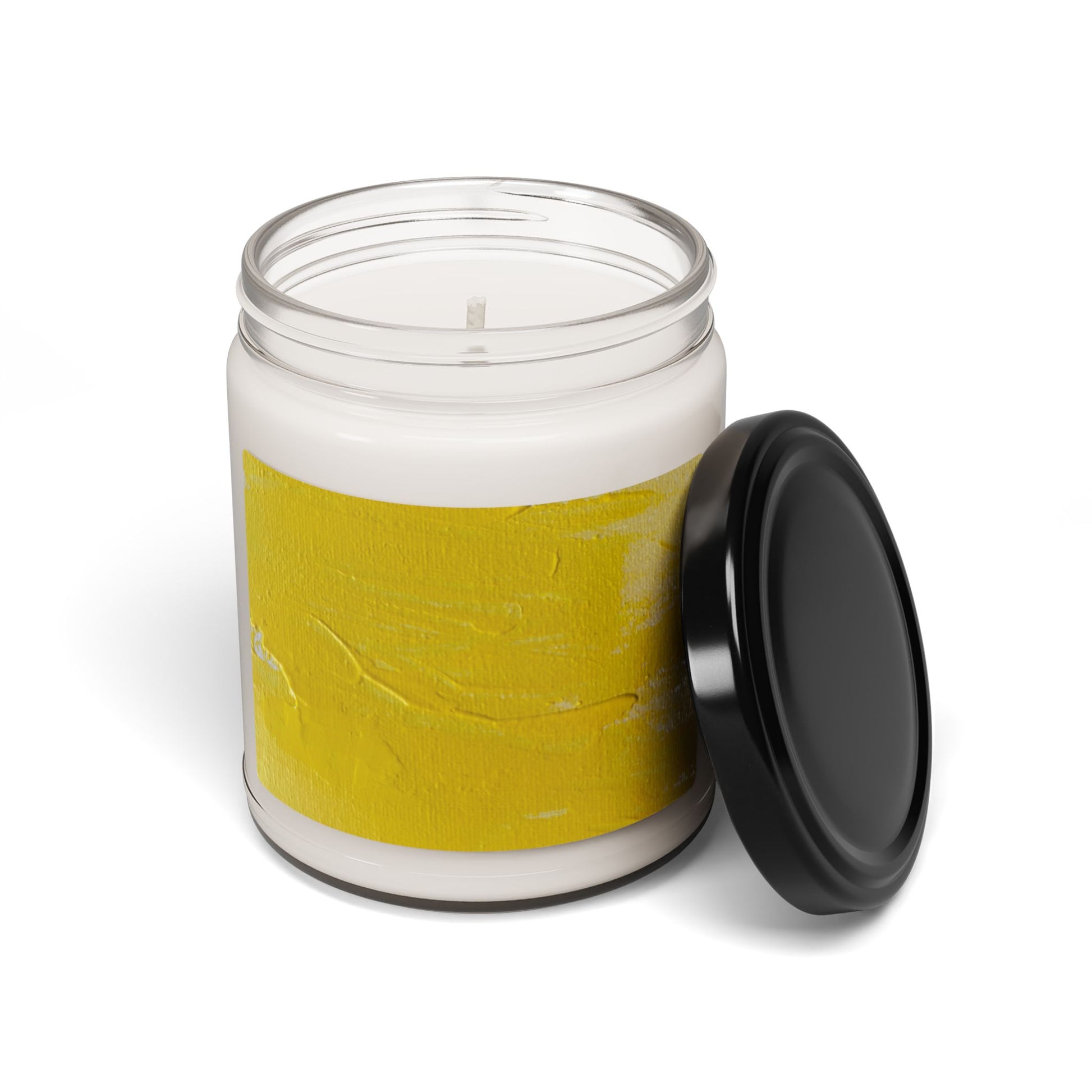 Soy candle in 9oz clear glass jar with yellow abstract painting label and black lid on white background
