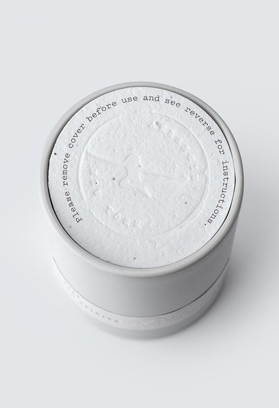 Top view of No. 51 Secret Garden candle with embossed paper seal and instruction text on white background