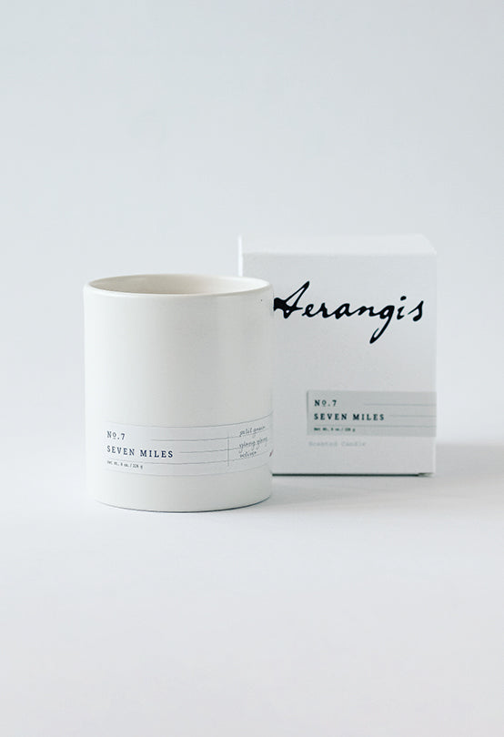 White ceramic candle holder labeled No.7 Seven Miles with matching Aerangis branded box on white background