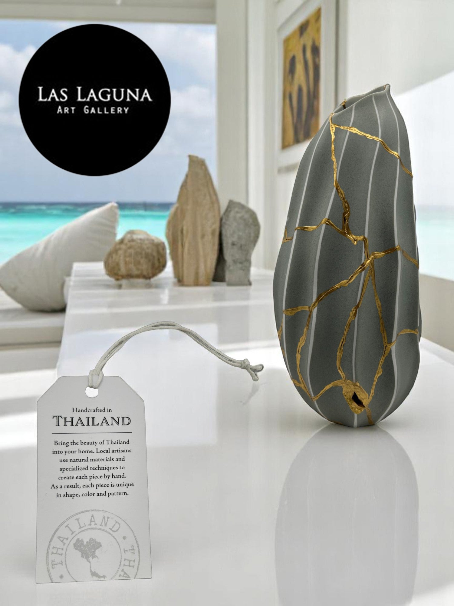 Gray melon-shaped vase with gold repaired cracks from Made In Thailand Collection on white surface