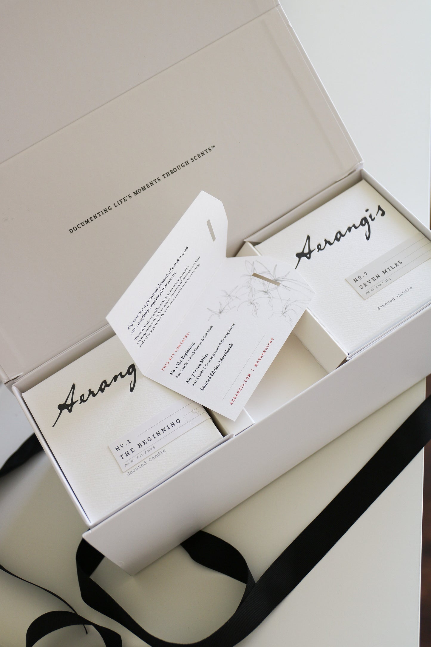 Vineyard Journey Gift Set with two Aerangis scented candles and an open card inside a white gift box with black ribbon